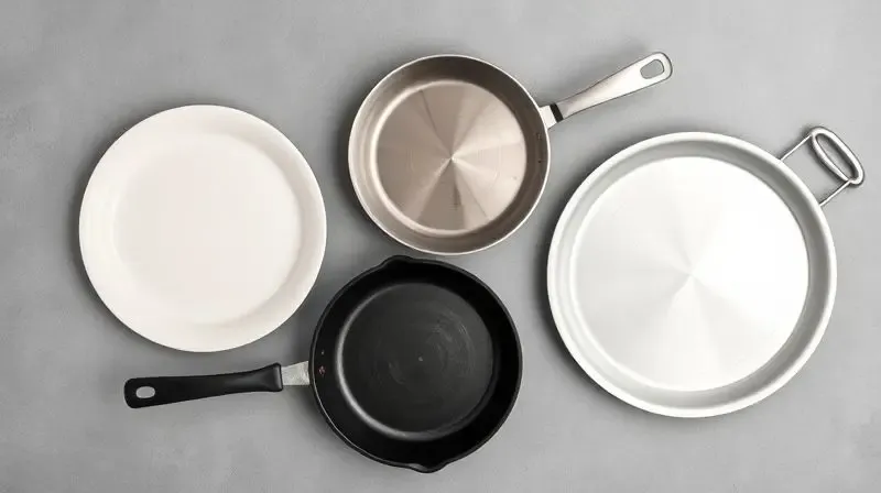 Vista superior de quatro panelas de materiais diferentes lado a lado: cerâmica, aço inox, ferro fundido e alumínio.